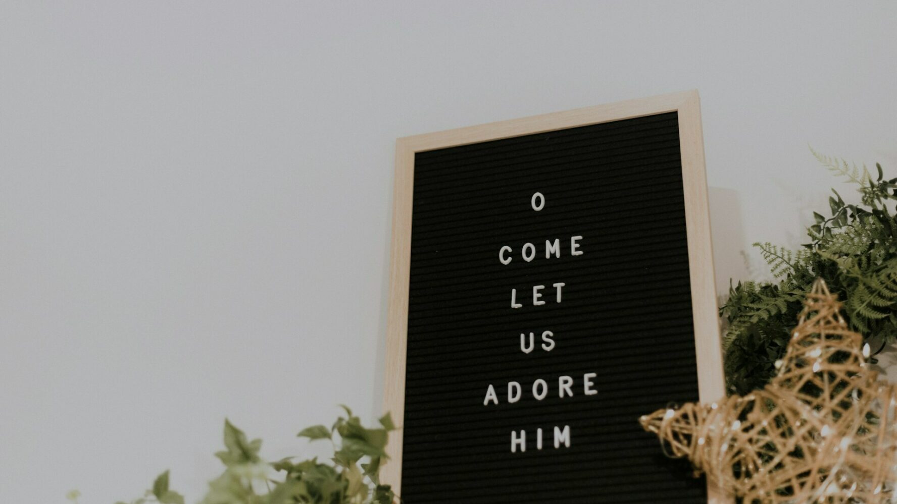 Letterboard sign that reads 'O come let us adore him'