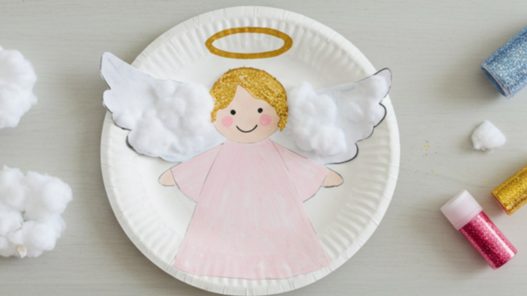 Image of a paper plate with a handmade angel on the front with glitter on