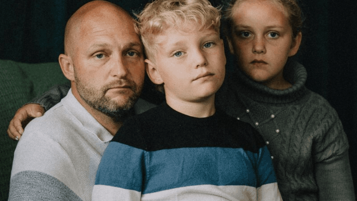 Paul and his two children, Vale and Eden, looking solemnly at the camera