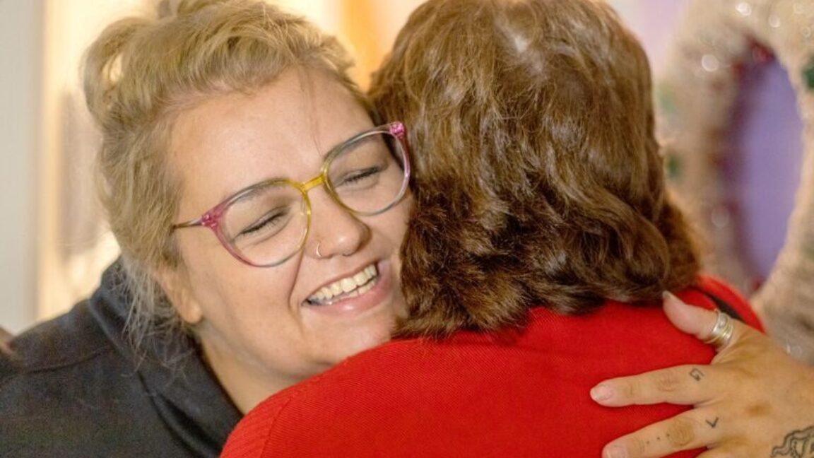 CAP client, Holly, hugging her CAP debt coach, Irene, in her home