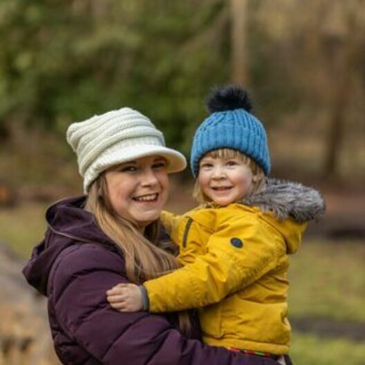 Client holding child looking at camera and smiling