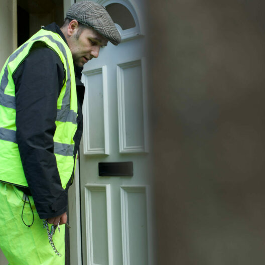 A man in stepping out of his front door to go to work, closing the door behind him