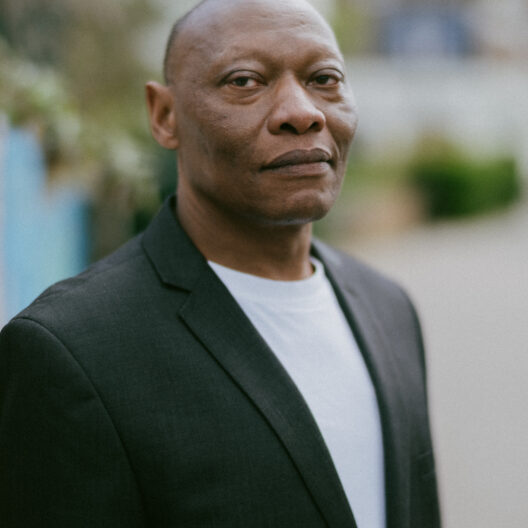 A man outside, looking reflective