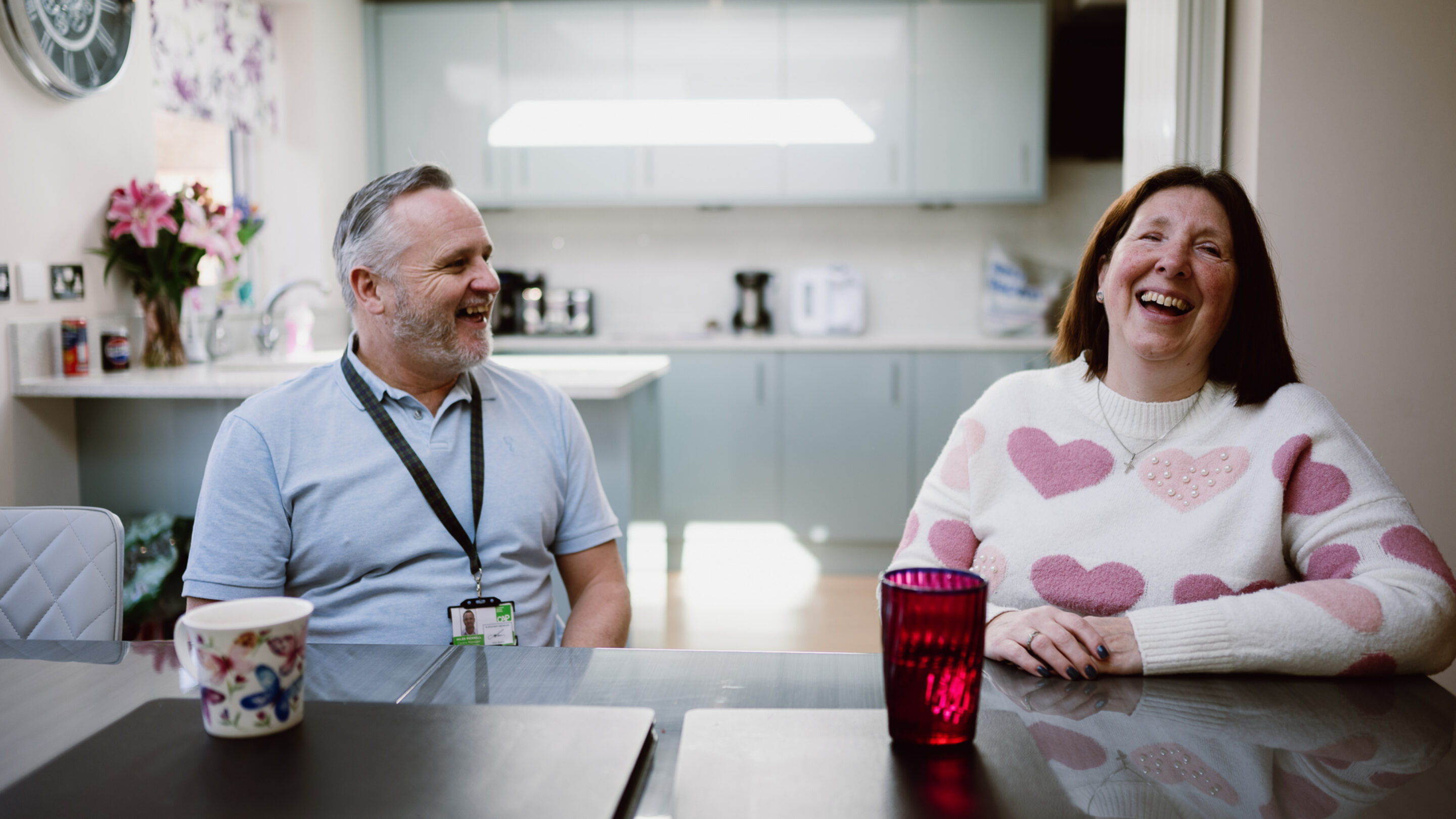 CAP client, Angela, sat in her kitchen with her debt coach, smiling