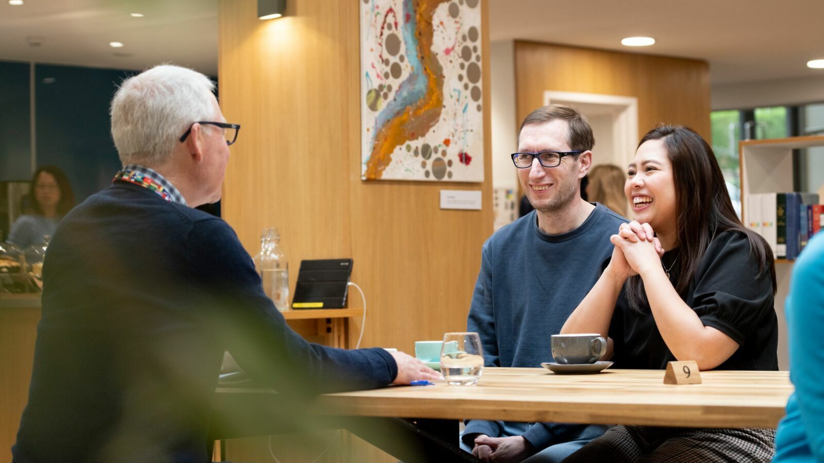 Two CAP clients at their local job club, sat at a table speaking to their job club coach