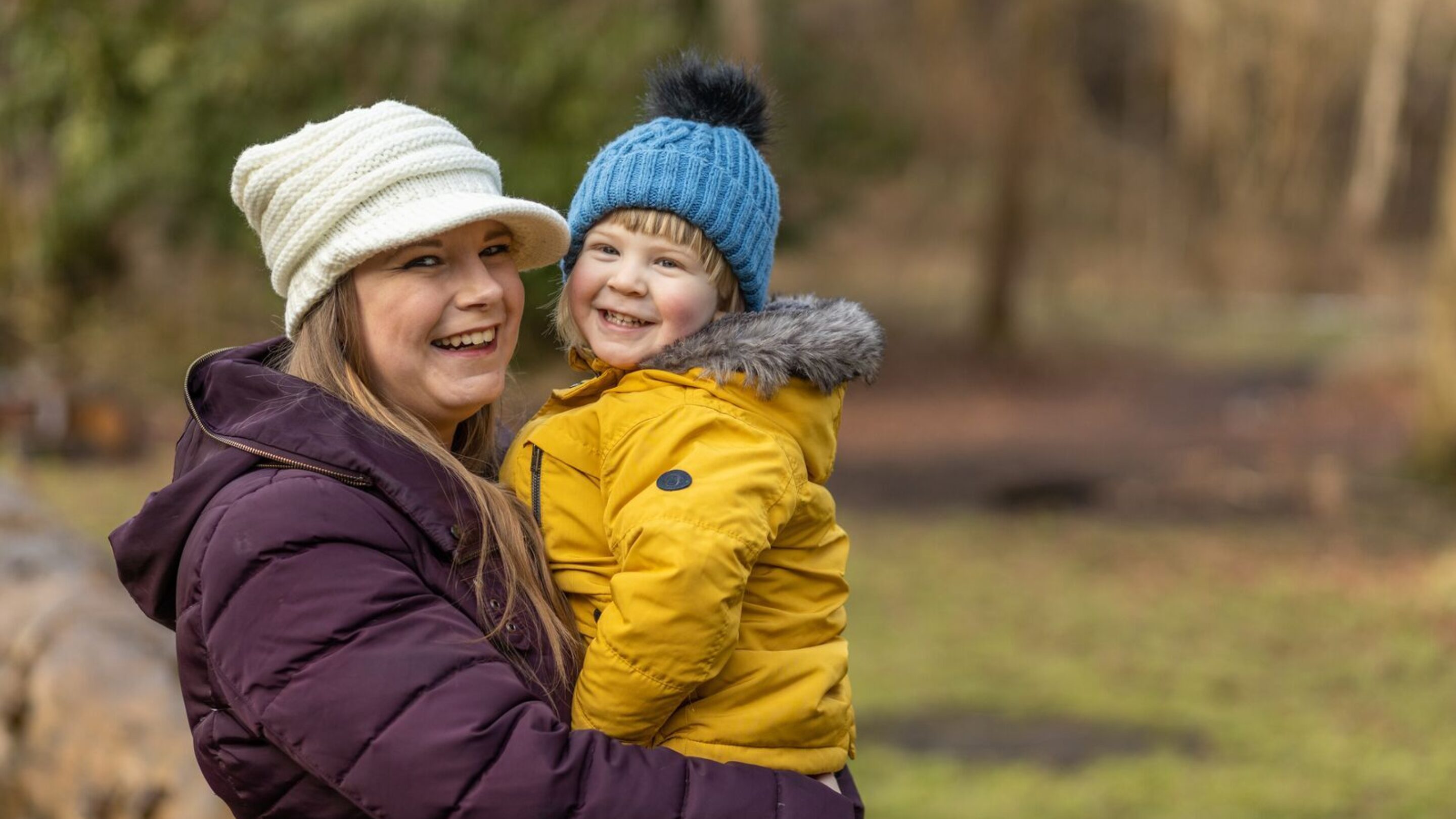 CAP client, Susan, smiling at the camera and holding her young child