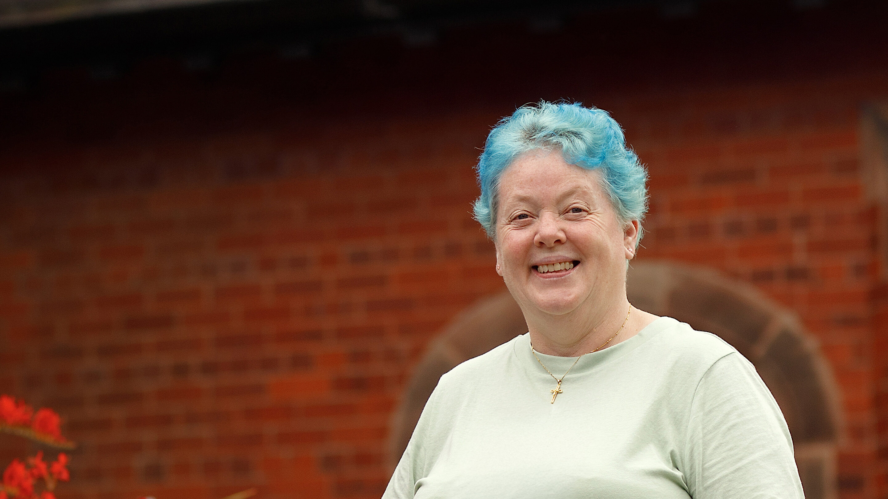 CAP client stood outside her local church, smiling at the camera