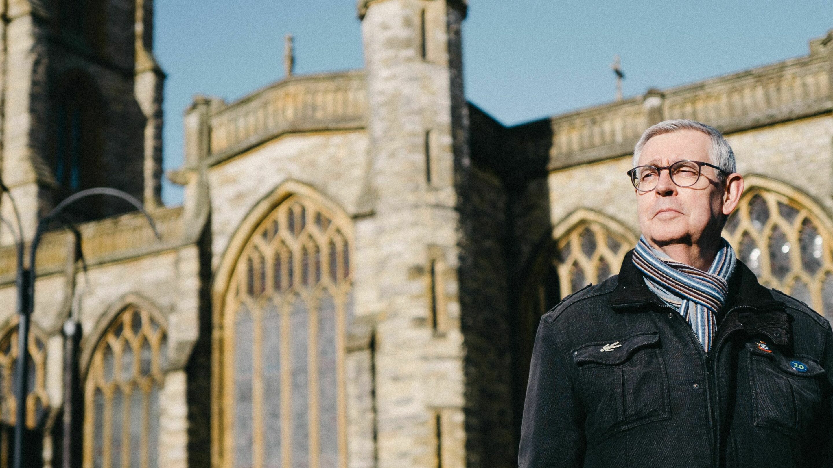 Debt coach Steve stood outside of a church building, looking into the distance