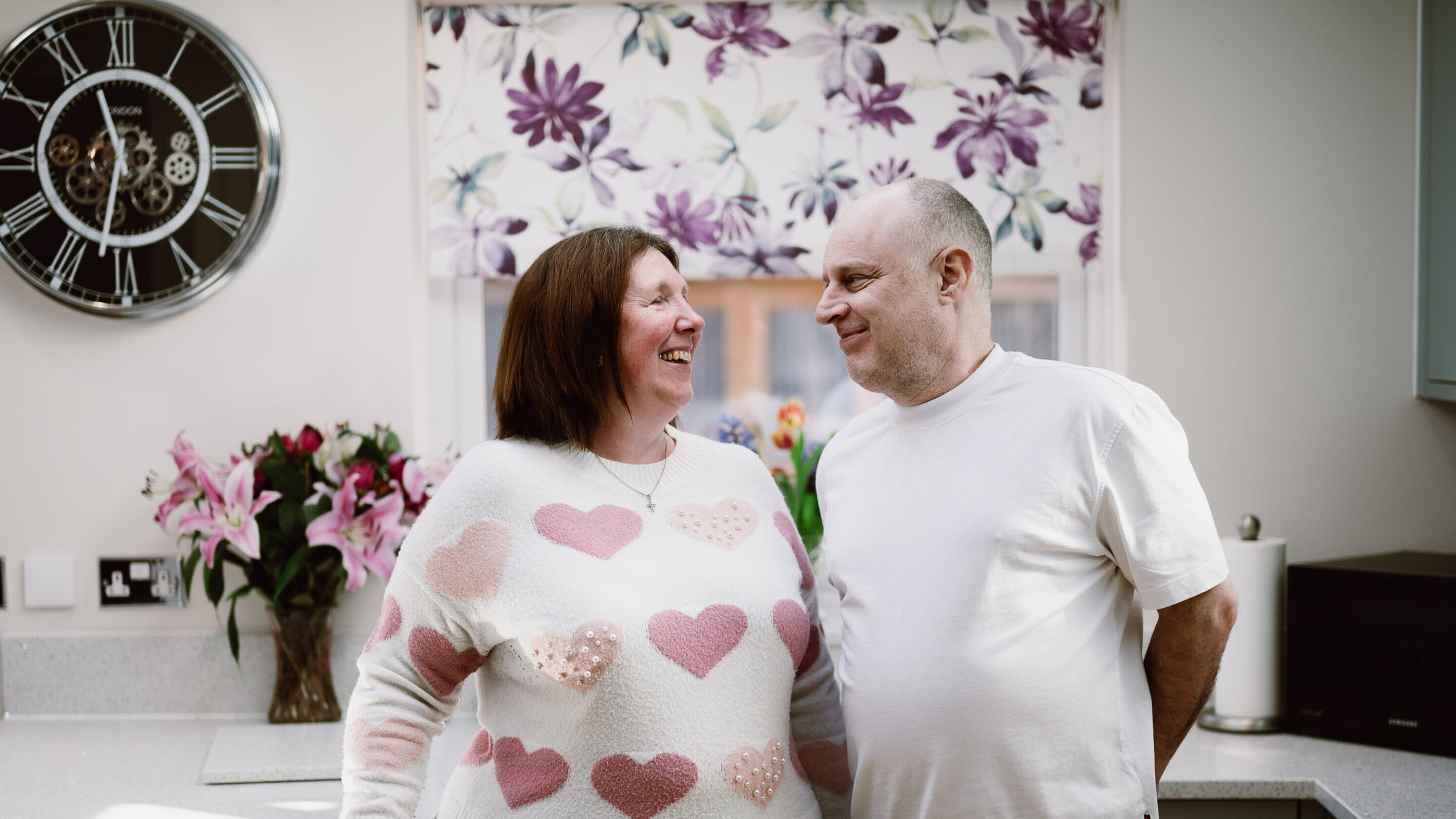 CAP client in her kitchen stood next to her husband and smiling at each other