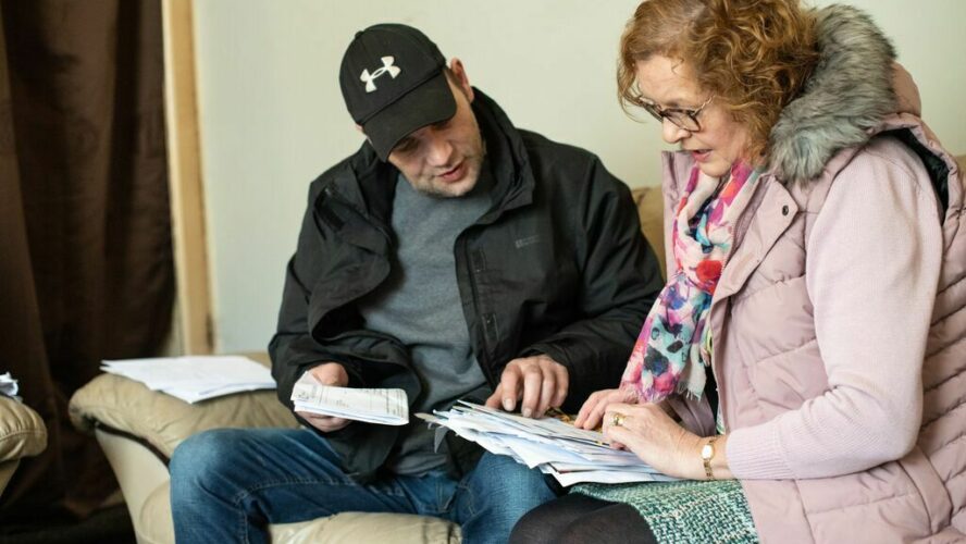 James, former CAP client, looking through paperwork with his CAP Debt Coach, Louise