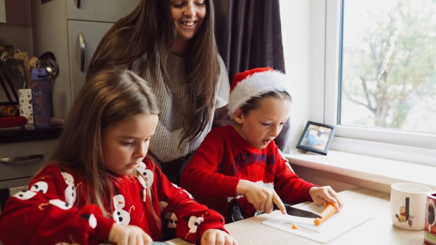 CAP client, Jade, with her two children, wearing Christmas jumpers and preparing Christmas dinner