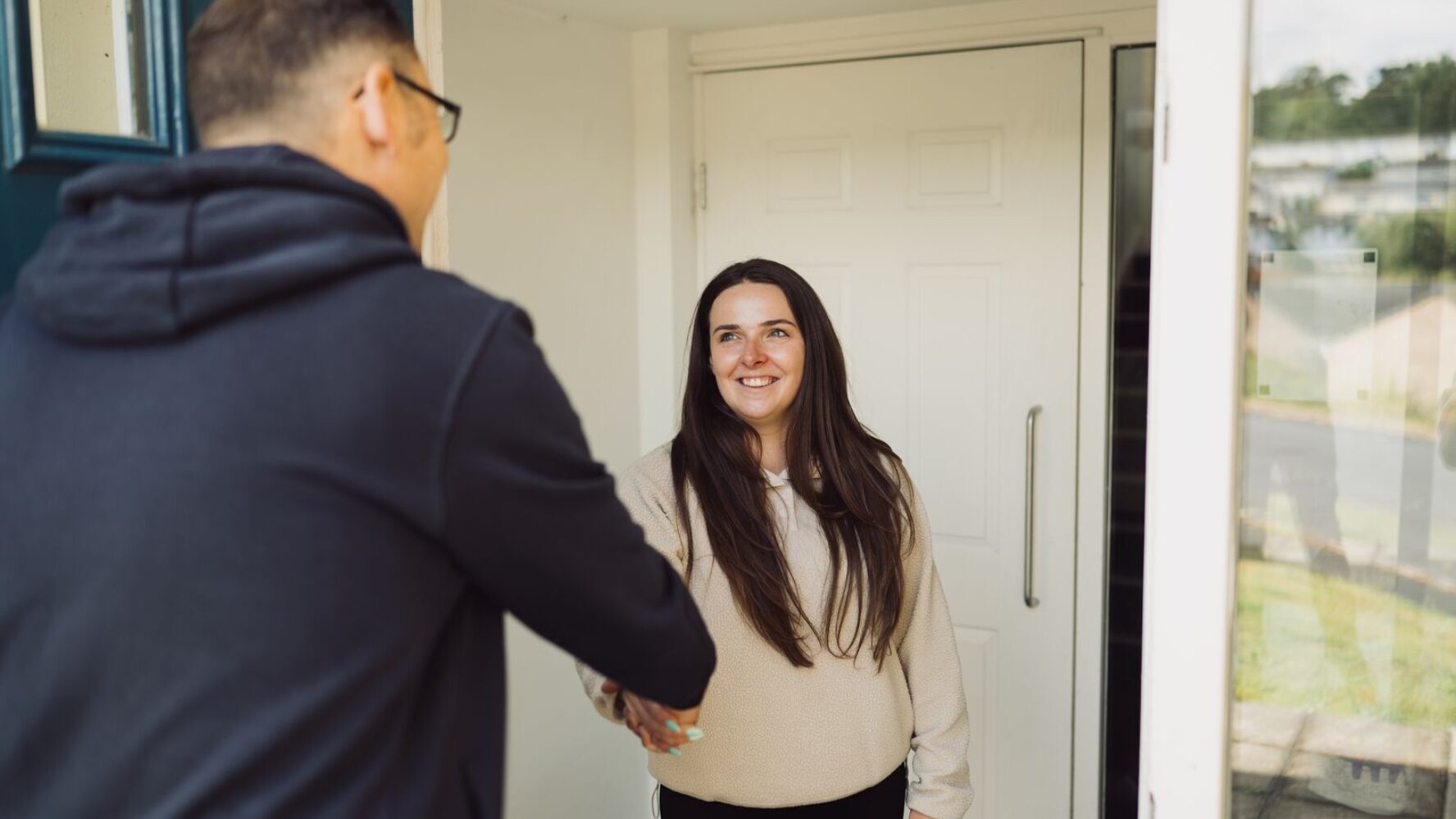 CAP client, Jade, stood at her front door, shaking hands with her local debt coach