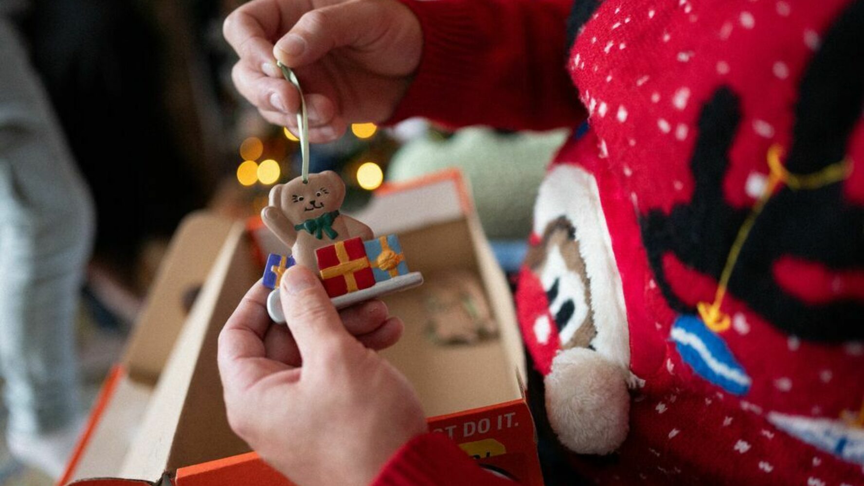 Image of a traditional Christmas ornament of a teddy bear with a present