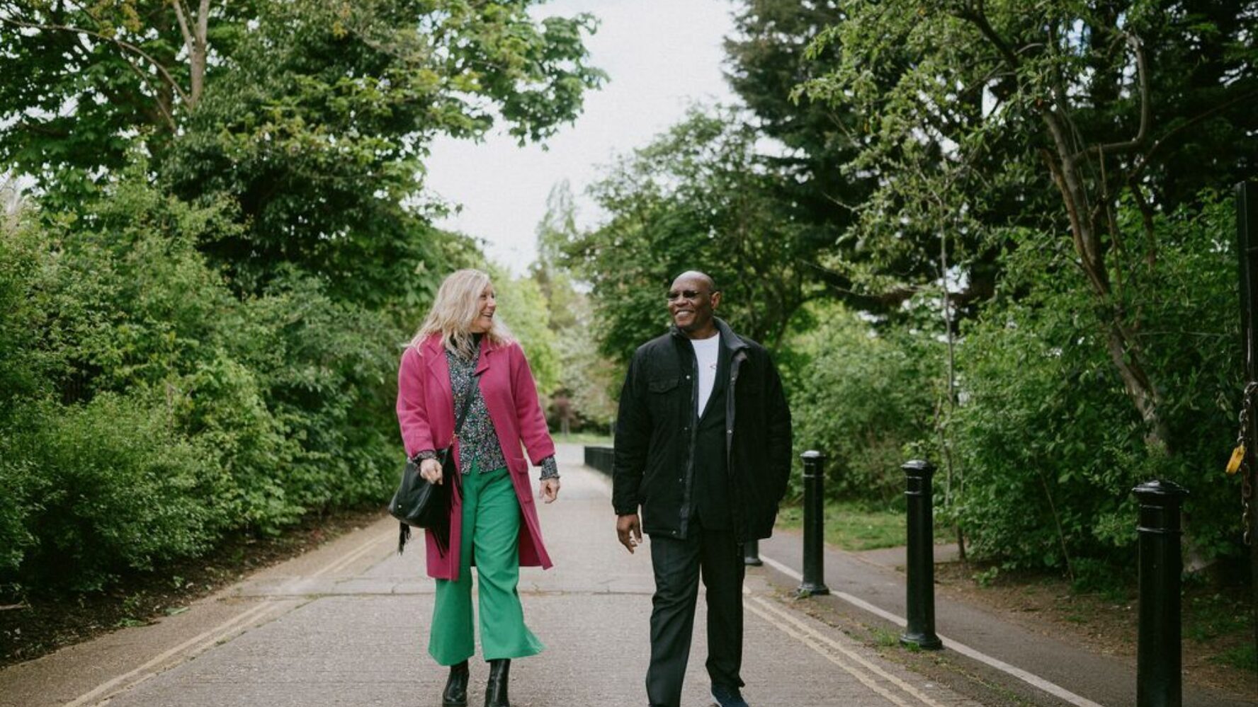 CAP Debt Coach, Ruth, walking in a park, smiling at CAP client, Jim