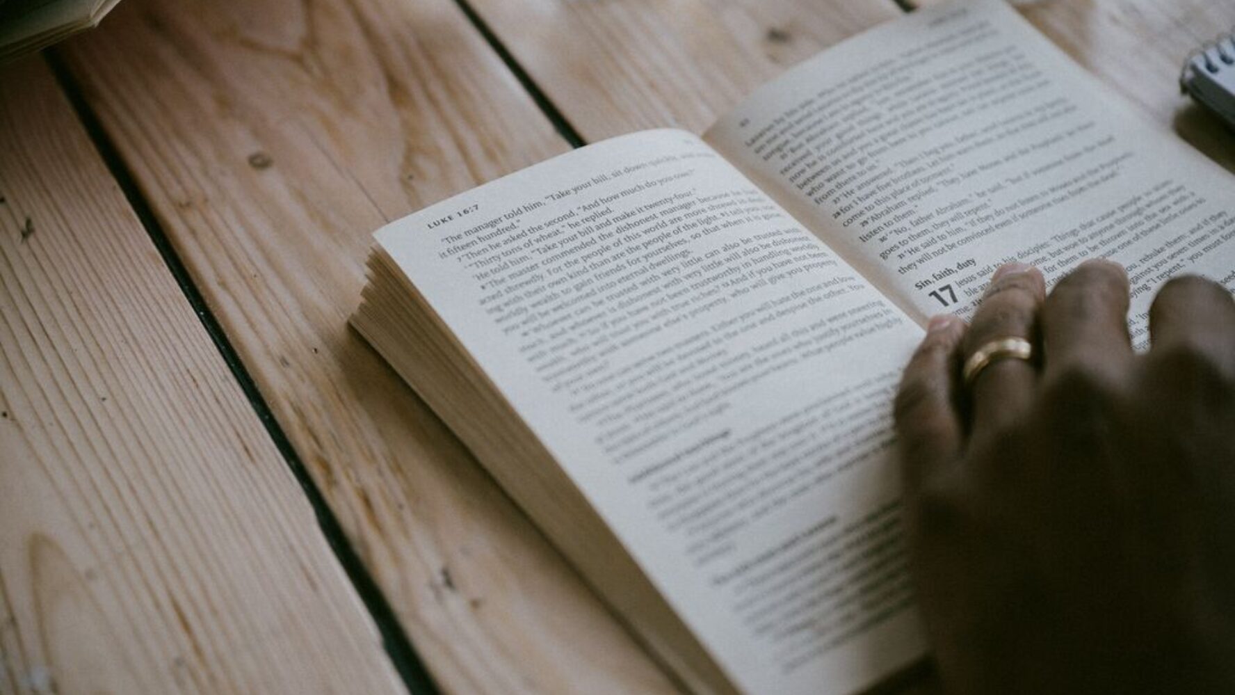 Person's hands holding the gospel of Luke