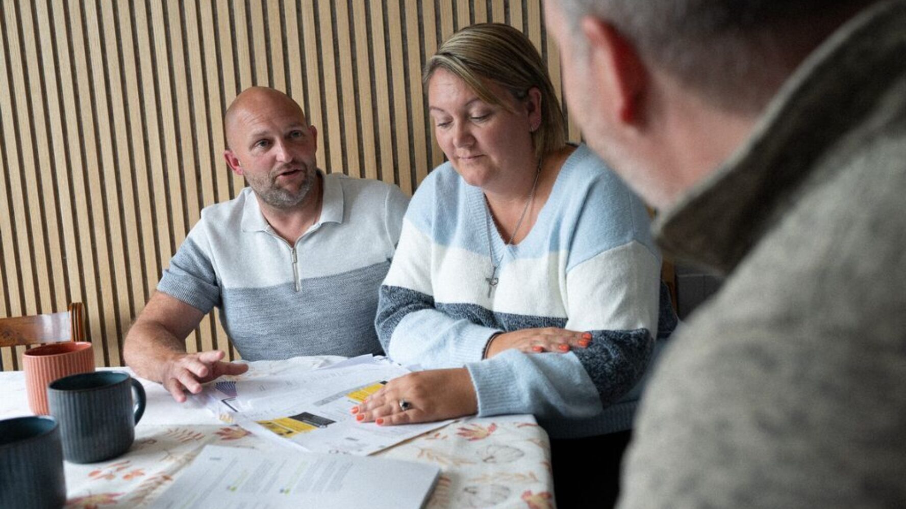 Two CAP clients talking with their debt coach in their home